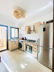 a kitchen with a stainless steel refrigerator and a dishwasher at Charmant Appartement 2 Room Wifi Marrakech in Marrakesh