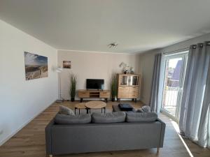 a living room with a couch and a tv at FeWo Foorden Wohnglück 3 in Hesel