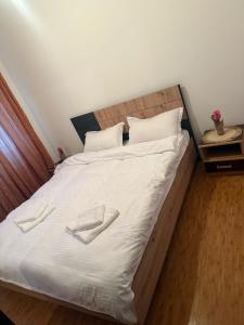 a large bed with white sheets and pillows on it at Apartament Karina in Dudu