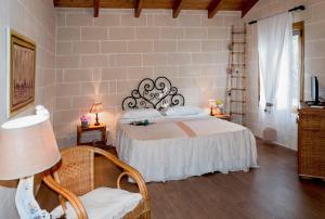 a bedroom with a large bed and a chair at Alba Bed & Breakfast in Melendugno