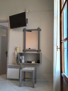 a room with a table and a tv on a wall at Liber-Mar apartments in Petra