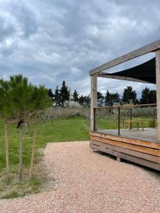 a wooden pavilion with a picnic table and a tree at Tiny Housse à la campagne in Sarrians +3 photos