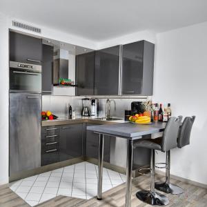 eine Küche mit schwarzen Schränken und einem Tisch mit Stühlen in der Unterkunft Exclusive Apartments Stuttgart - Gablenberg in Stuttgart