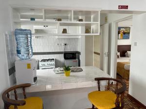 eine Küche mit einer Theke mit 2 Stühlen und einem Tisch in der Unterkunft Lantana Suites in Nairobi