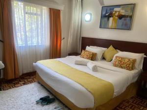 ein Schlafzimmer mit einem großen Bett in einem Hotelzimmer in der Unterkunft Lantana Suites in Nairobi