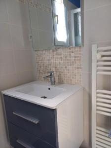 un bagno con lavandino e specchio di Evasion à Meschers Piscine Plage Tennis Famille a Meschers-sur-Gironde