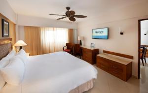 a bedroom with a white bed and a ceiling fan at Occidental Caribe - All Inclusive in Punta Cana