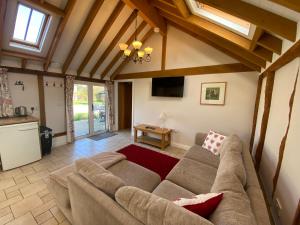 a living room with a couch and a table at Oak Apple in Plaitford