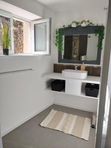 a white bathroom with a sink and a mirror at La petite maison de poncho in Le Blanc +37 photos