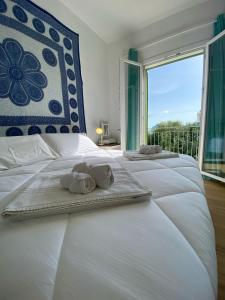 a bedroom with two white towels on a bed with a window at Villa Ortensia in Cefalù