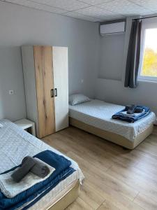 a bedroom with two beds and a window at Стаи за гости Крис in Vratsa