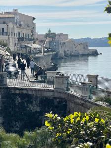 a group of people walking on a bridge over the water at margherita house in Avola