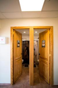 a bathroom with two wooden doors and a toilet at Posada Rancho Malcaminos in Tabernas