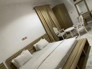 a bedroom with a bed and a table and chairs at Ibiyemi apartment in Abuja