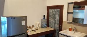 a small kitchen with a refrigerator and a sink at Castaway Surf Retreat in Sekongkang