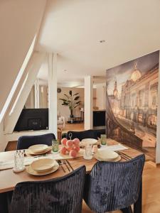 una sala da pranzo con tavolo, sedie e un quadro di Elegantes Loft mit 2 Etagen im Königsviertel a Dresda