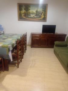 a room with a table and a couch and a laptop at Apartamentos cañamares in Cañamares