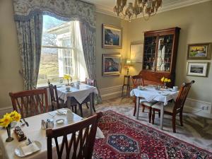 a dining room with two tables and a window at Craggan in Ballater