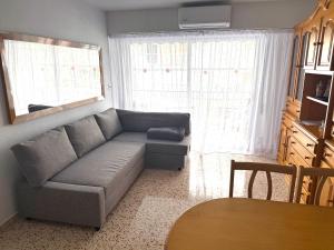 a living room with a couch in front of a window at La Turia Soleada in Cullera
