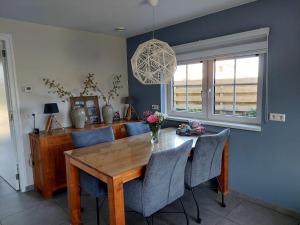 a dining room with a wooden table and chairs at An en Bie in Aagtekerke
