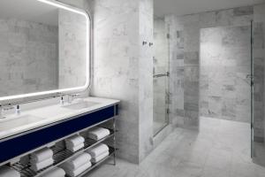 un baño con lavabo y ducha en Fontainebleau Miami Beach, en Miami Beach
