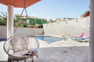 a swinging chair next to a swimming pool at Sunstay Chalet La Colina Torremolinos in Torremolinos