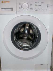 a white washing machine with its door open at Apartament Costescu in Băile Herculane