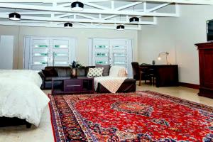 a living room with a bed and a red rug at Munro Suites in Port Elizabeth +23 photos