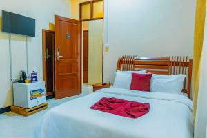 a bedroom with a white bed with a red towel on it at KC Executive Lodge in Kikuyu