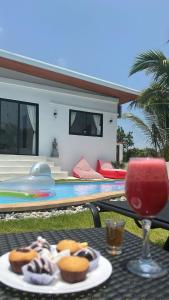 a table with a plate of donuts and a drink at Villa Nature Tropicale et Lac au centre de Koh Samui Chaweng in Koh Samui 