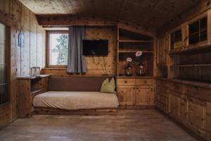a bedroom with a bed in a wooden room at Töllhof STUDIO mit BAUERNSTUBE in Bressanone