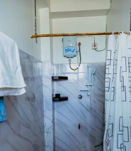 a bathroom with a shower with a shower curtain at Abella Rentals in Moshi