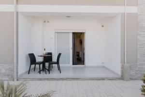 a patio with a table and chairs on a white wall at Residenza Kalios in Tropea +55 photos