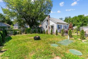 a backyard with a grill in the grass at Portsmouth Beach cottage in Portsmouth
