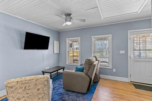 a living room with a couch and a tv at Portsmouth Beach cottage in Portsmouth