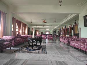 プシュカルにあるUmaid Mahal Palaceのピンクのソファとテーブルが備わる部屋