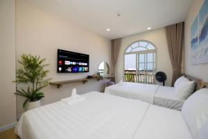 a hotel room with two beds and a window at Lotus Home Cafe - Cable Car Station in Phú Quốc