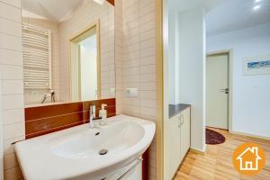 Un baño con un lavabo blanco y un espejo. en Apartamenty Zacisze Leśne - visitopl, en Świnoujście 22 fotos más