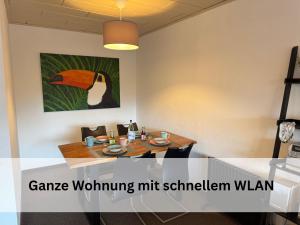 une salle à manger avec une table et une photo d'un oiseau dans l'établissement FeWo Berg-Domizil Altenau inklusive Bettwäsche und Handtüchern, à Altenau