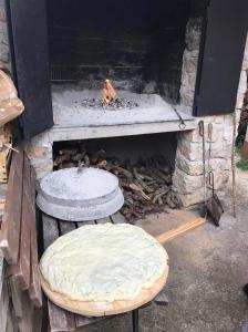 a stone fireplace with two stools and a pizza oven at Carpe Diem in Raslina