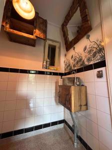 Un baño con un lavabo y un espejo en la pared. en Sfeervol Overnachten in de Kerk, en Amersfoort 20 fotos más