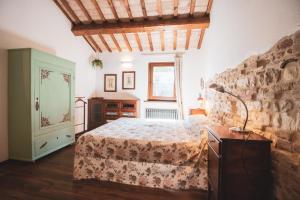 a bedroom with a bed and a stone wall at Villa Altrove in Montemarciano