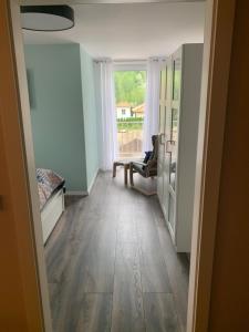 a room with a hallway with wooden floors and a window at Linke Ferienwohnung im Ferienhaus Seestern in 06249 Mücheln in Büchel +4 photos
