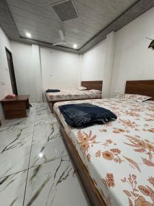 three beds in a room with marble floors at Hotel Shree Siddhi vinayak in Ujjain +18 photos