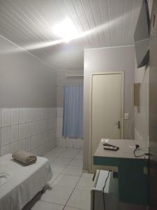 a bathroom with a bed and a sink and a mirror at Hotel Porto Amazônia in Porto Velho