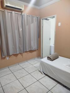 a bedroom with a bed and a window with curtains at Hotel Porto Amazônia in Porto Velho