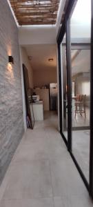 an empty room with glass doors and a kitchen at Casa Bella vista in Paysandú