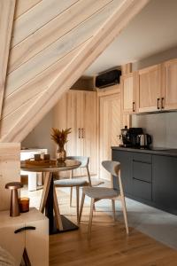 a kitchen with a table and chairs in a room at Villa Las Apartamenty in Zakopane