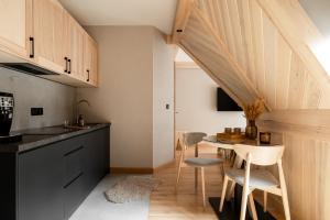 a kitchen with a table and chairs in a kitchen at Villa Las Apartamenty in Zakopane +40 photos