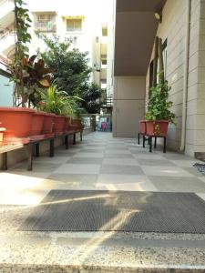 a hallway with benches and potted plants on a building at Elegant City Retreat in Vadodara